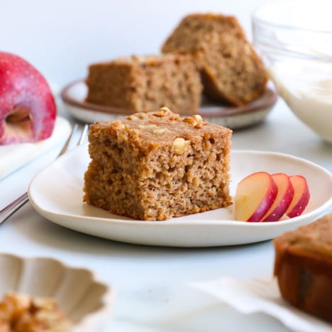 applesauce cake on a plate with red apple slices.