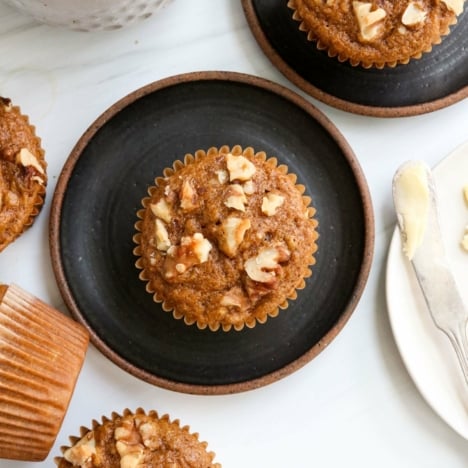 healthy banana muffins on black plates overhead.