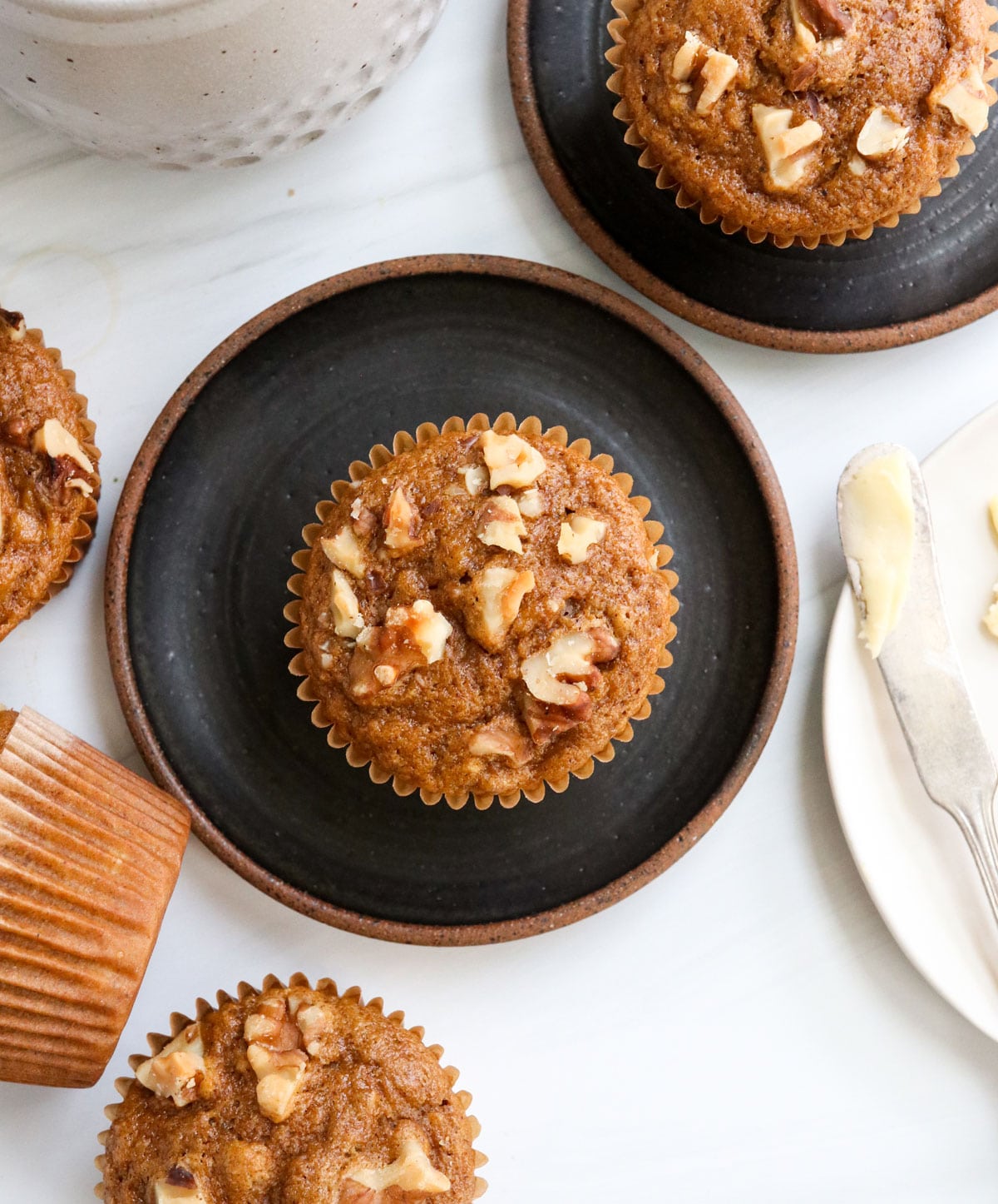 healthy banana muffins on black plates overhead.