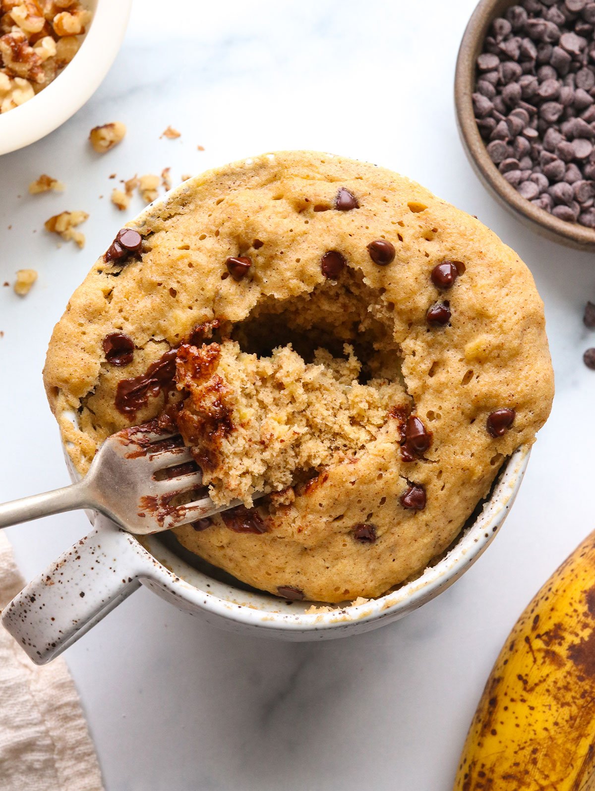 banana mug cake topped with chocolate chips close-up with a fork.