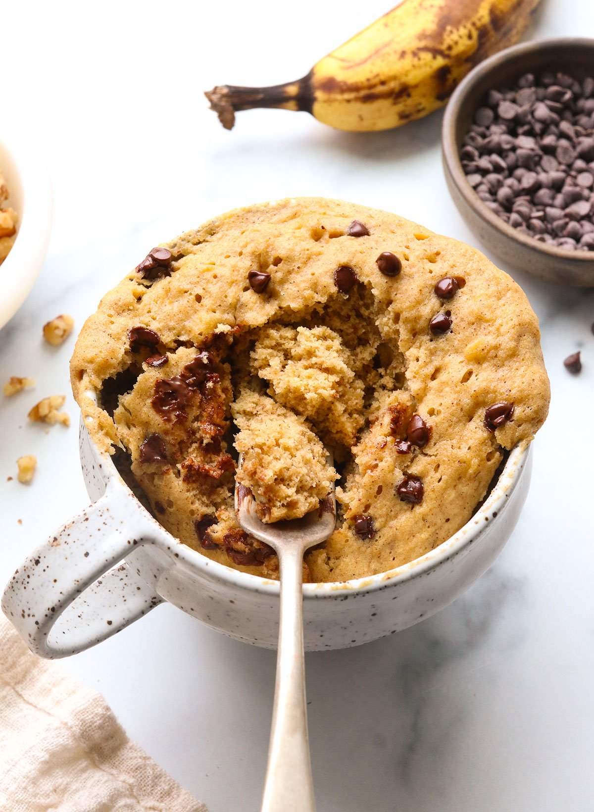 fork lifting up a bite of cooked mug cake to show the fluffy texture.