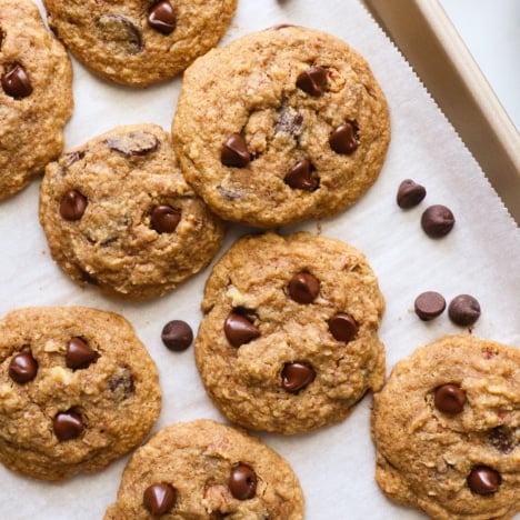 several buckwheat chocolate chip cookies arranged on a lined baking sheet.