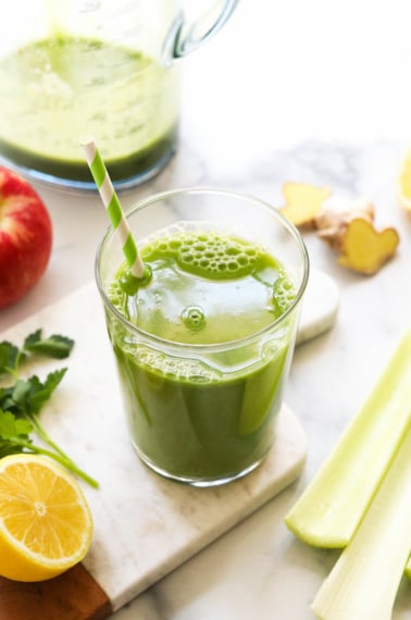 detox juice served in a glass with a striped straw.