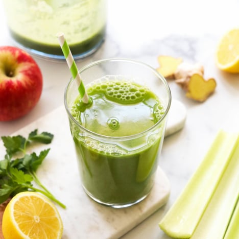 detox juice served in a glass with a striped straw.