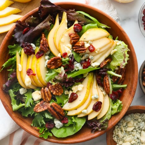 pear salad served with cranberries and pecans on top.