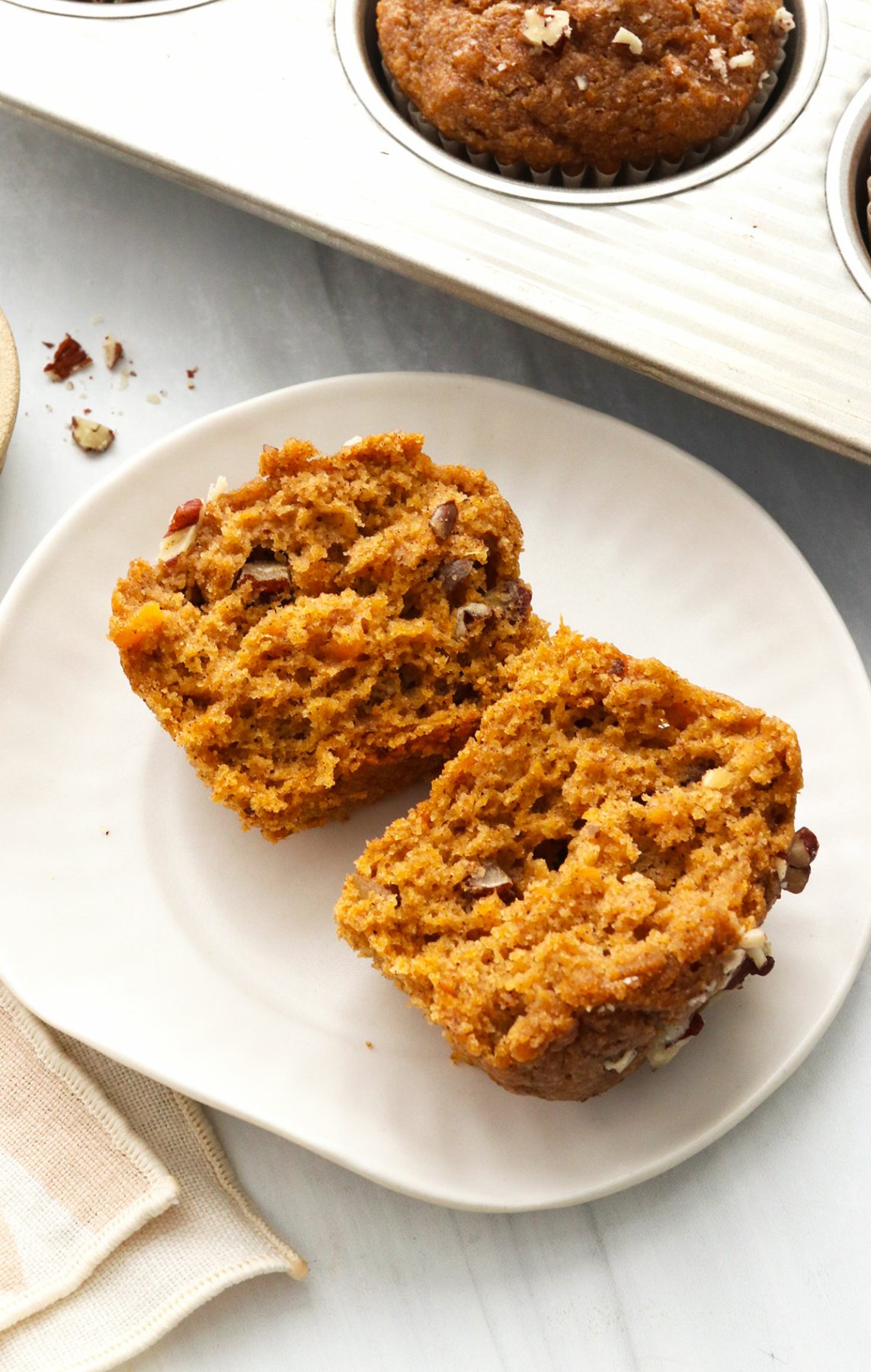 Sweet potato muffin split in half on a white plate.