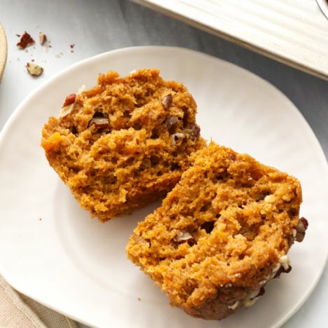 Sweet potato muffin split in half on a white plate.