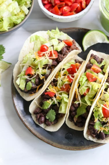 black bean tacos on black plate.