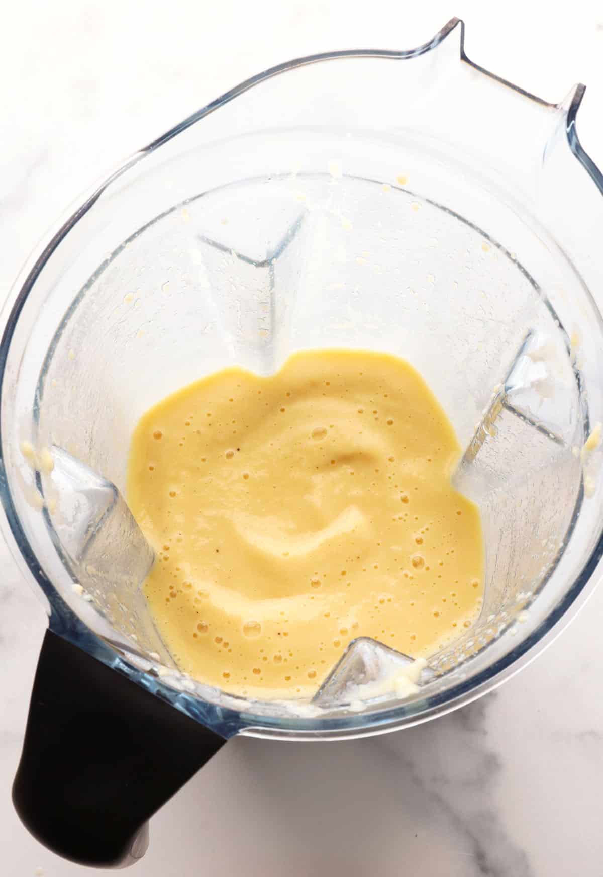 pineapple banana smoothie blended in a blender pitcher.