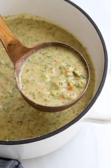 broccoli cheddar soup lifted up on ladle.