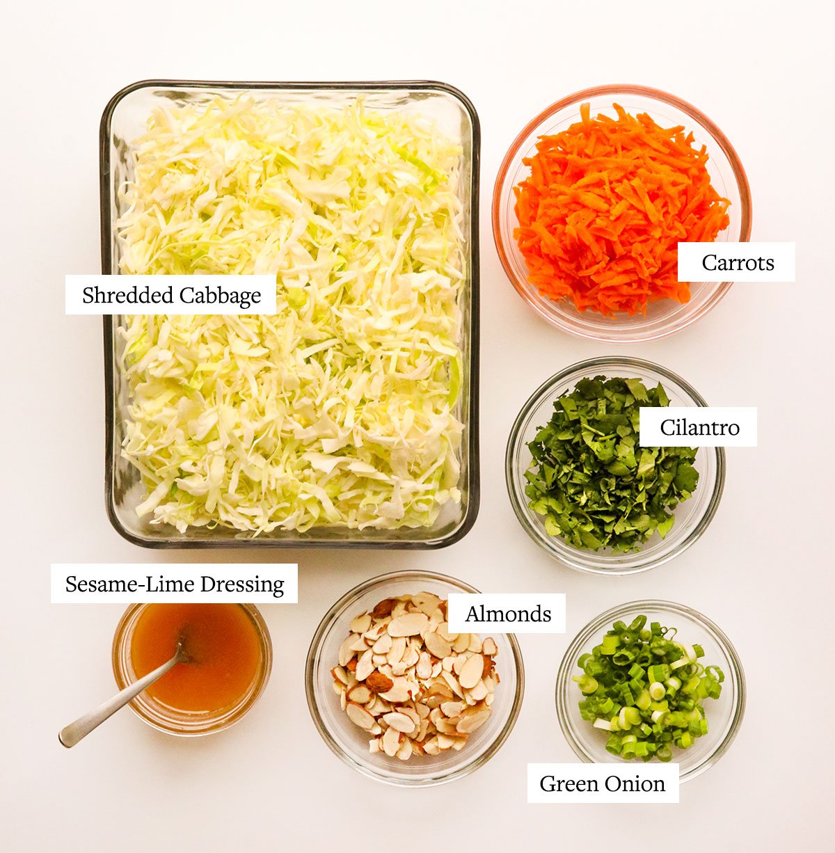 cabbage salad ingredients labeled on a white surface.