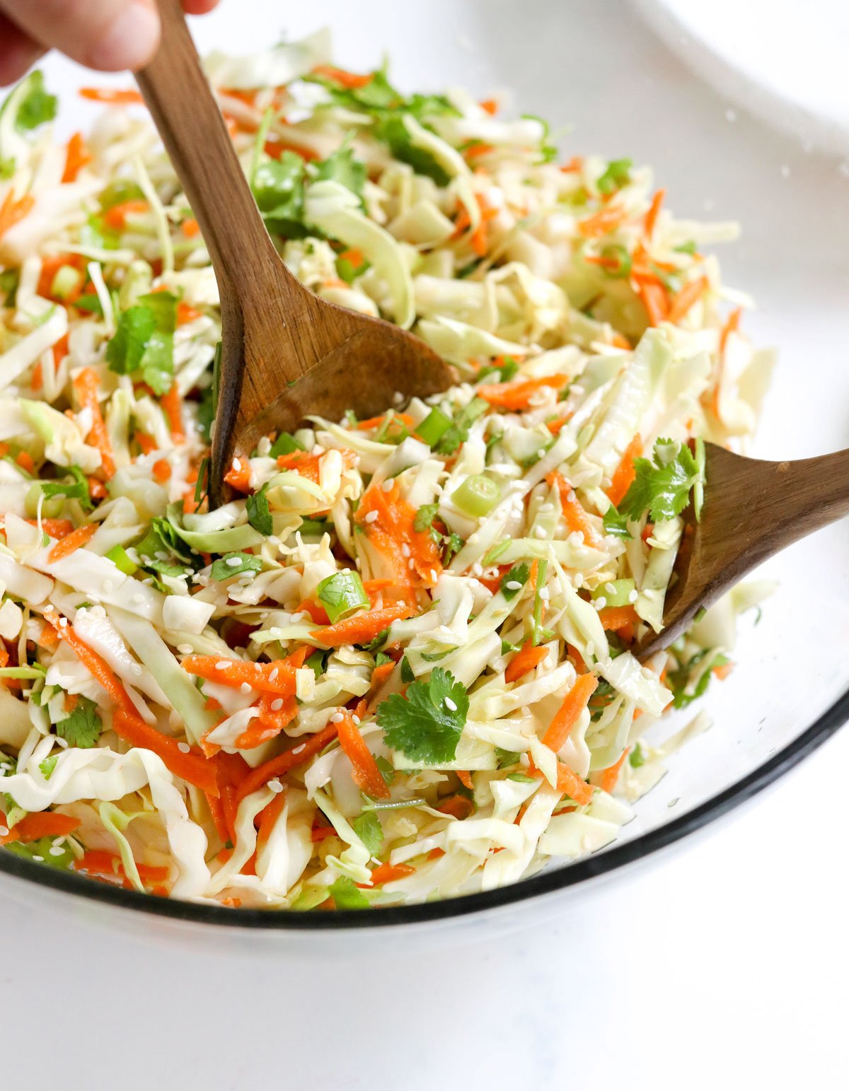 cabbage salad in bowl with tongs