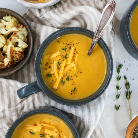 cauliflower cheese soup in dark blue mugs.