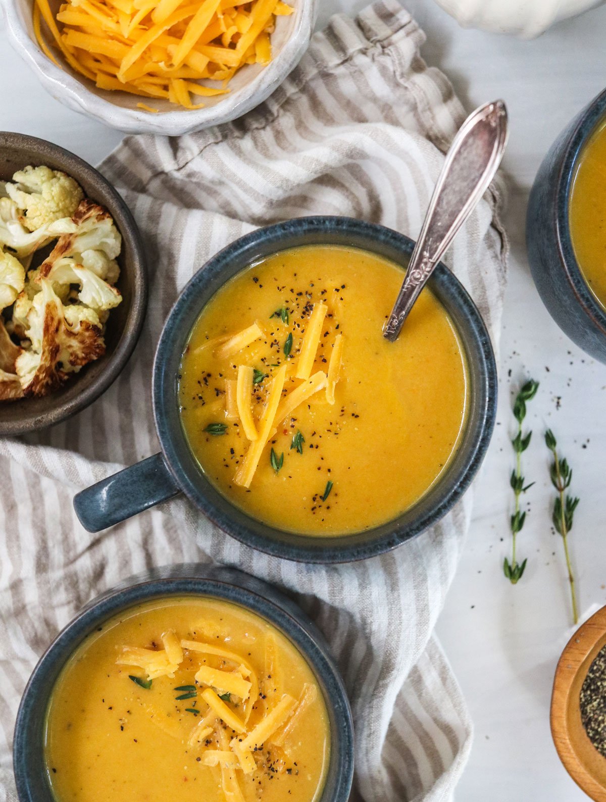 cauliflower cheese soup in dark blue mugs.