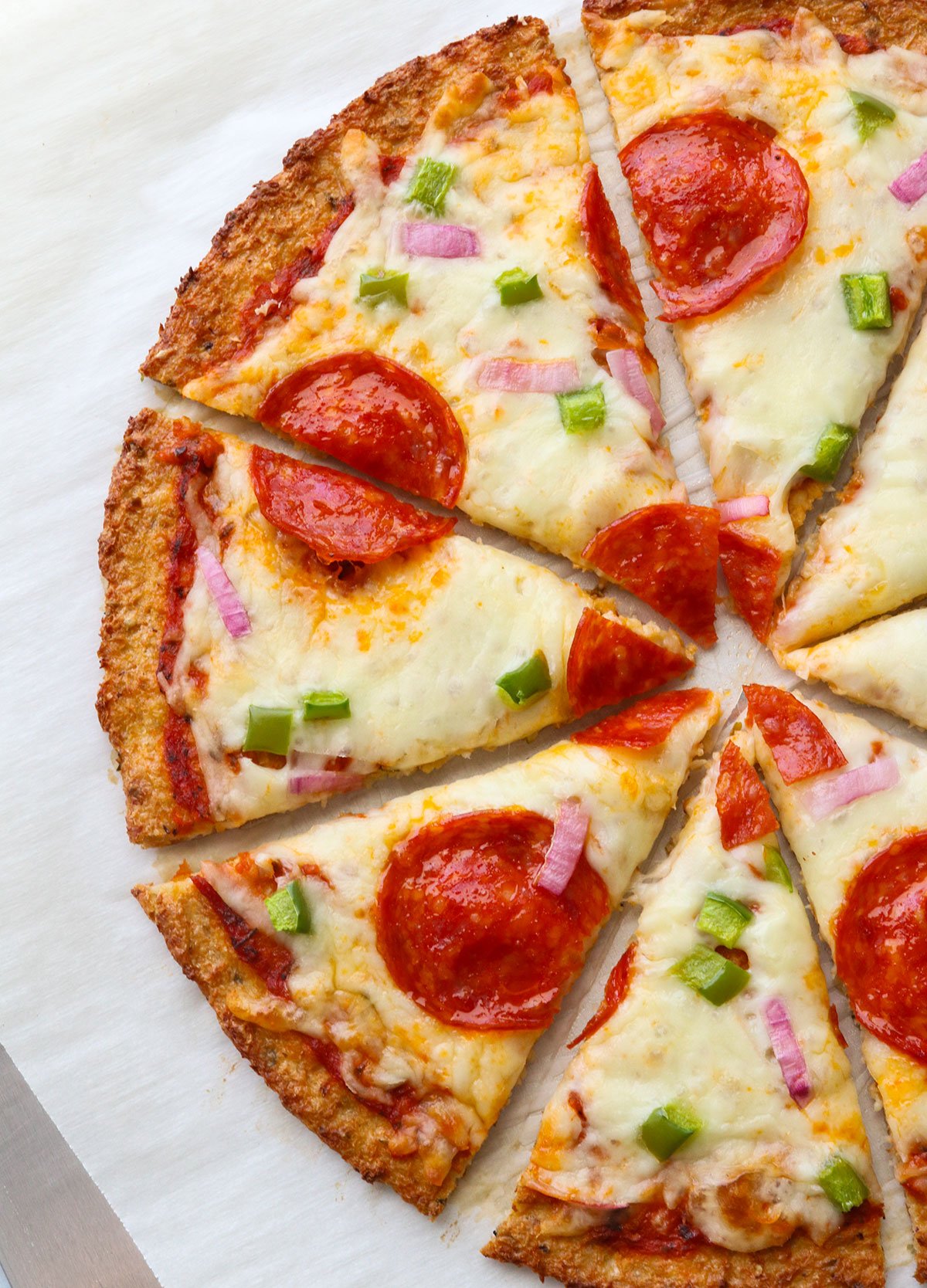 Finished cauliflower pizza cut into slices.