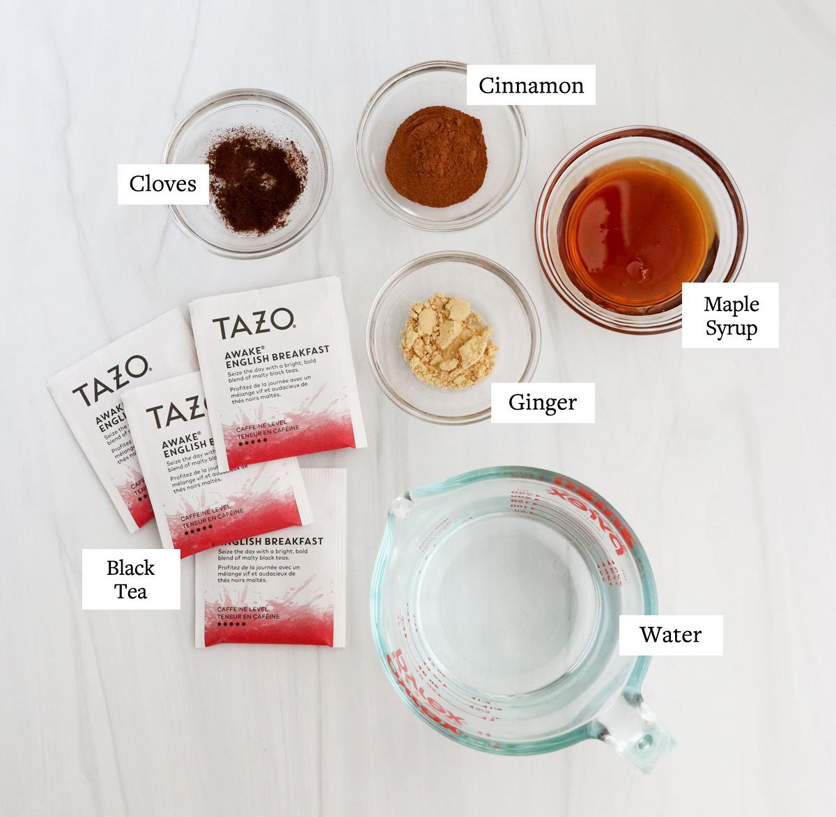 chai tea concentrate ingredients on white surface.