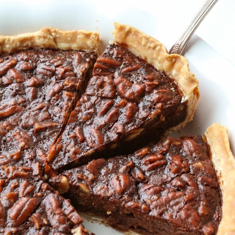 Chocolate pecan pie slice lifted up from a pie pan.