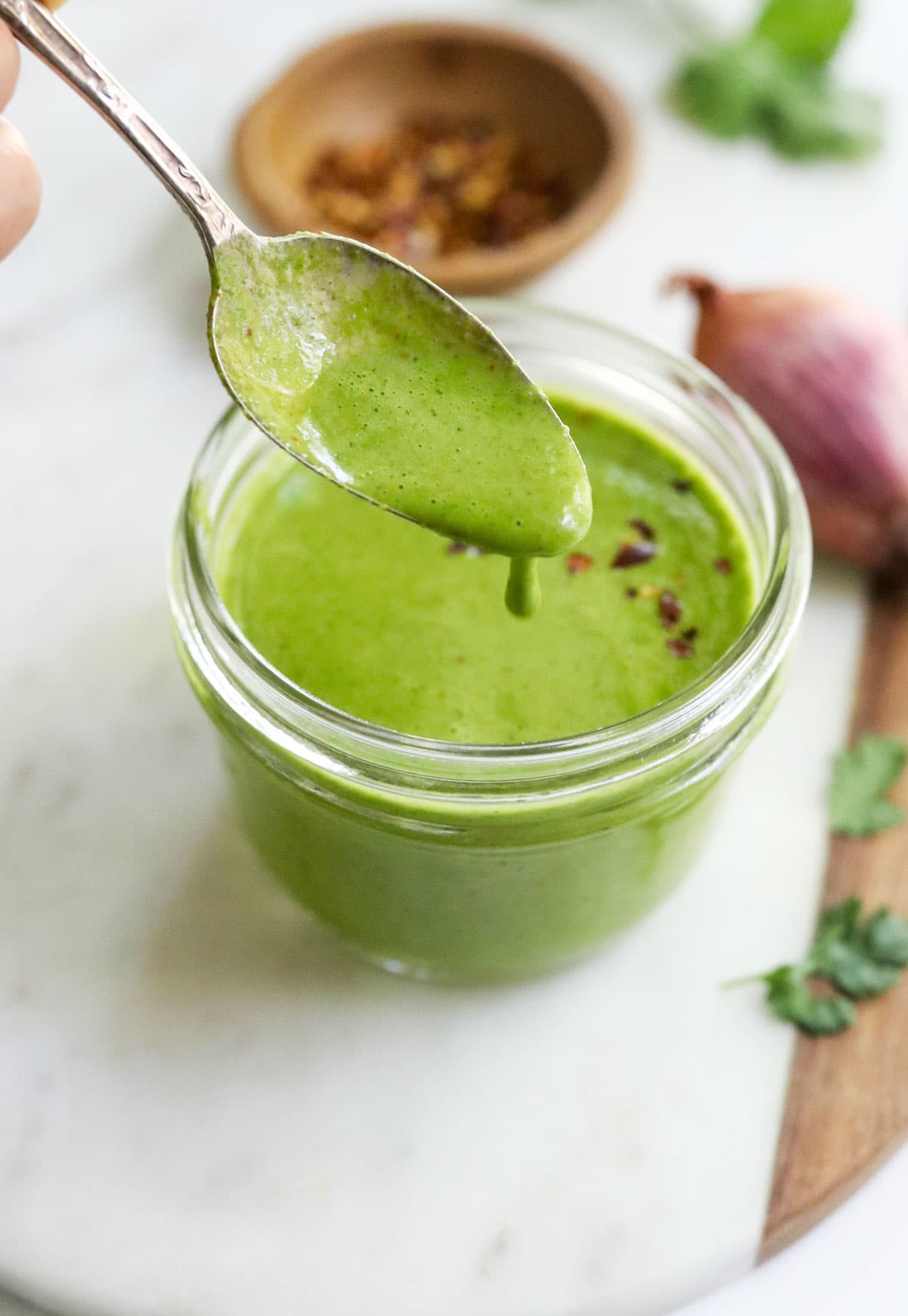 cilantro sauce dripping off of a spoon