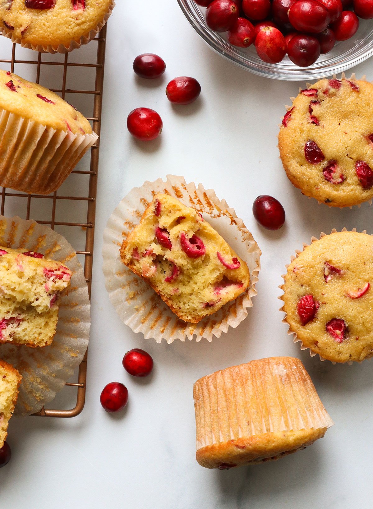 cranberry muffin split in half near cranberries. 