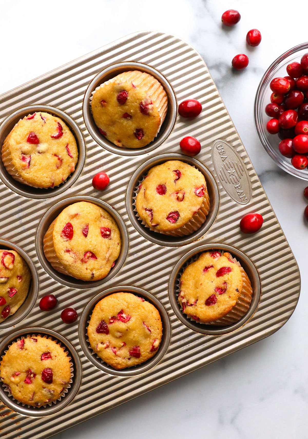 almond flour cranberry muffins cooled in a muffin tin.