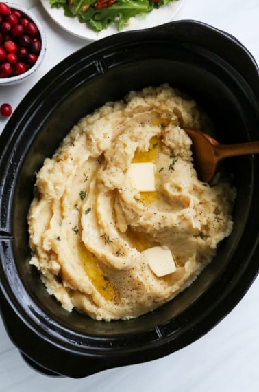 mashed potatoes served in slow cooker with butter on top.