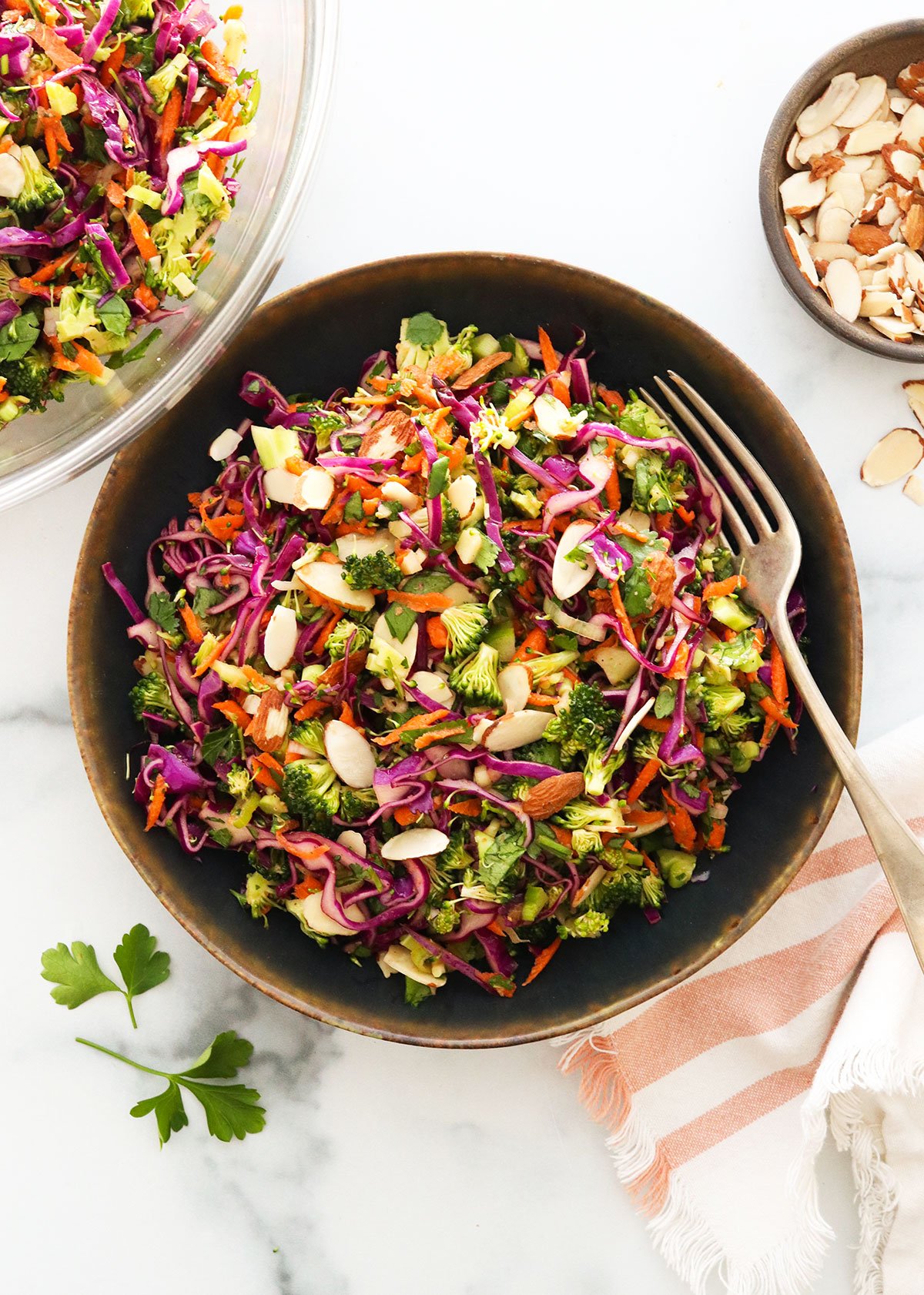 detox salad in a black bowl topped with sliced almonds.