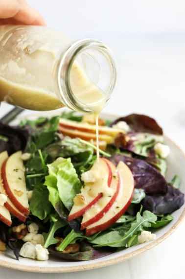 champagne vinaigrette poured over salad from a bottle.