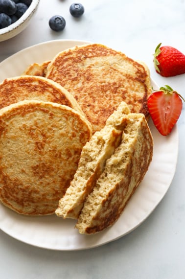 pancake ripped in half on a plate to show the fluffy texture.