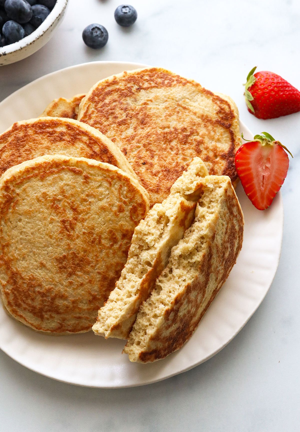 pancake ripped in half on a plate to show the fluffy texture.