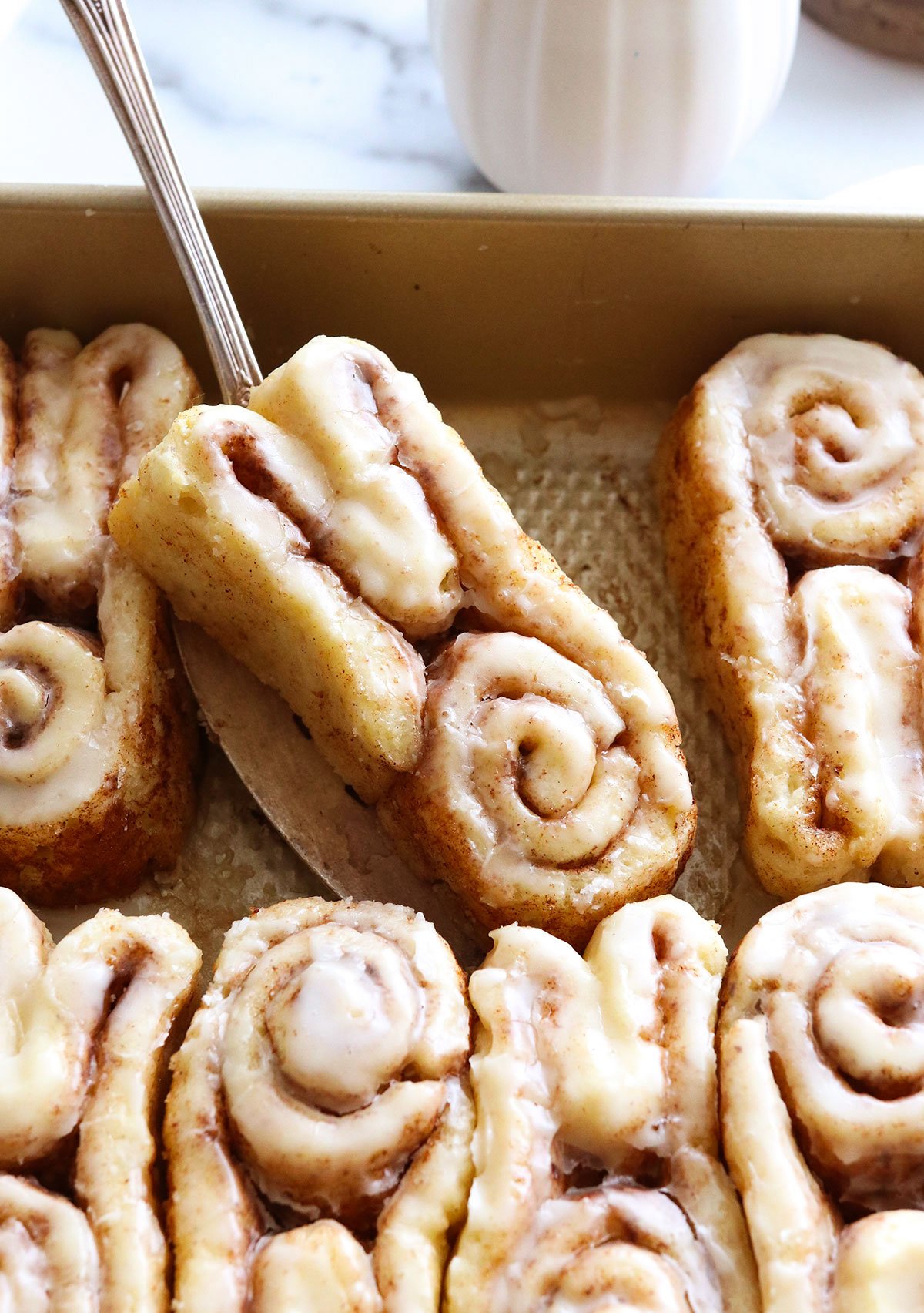 gluten free bunny cinnamon roll lifted up on a spatula.