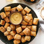 gluten-free pretzels on a black plate with honey mustard.