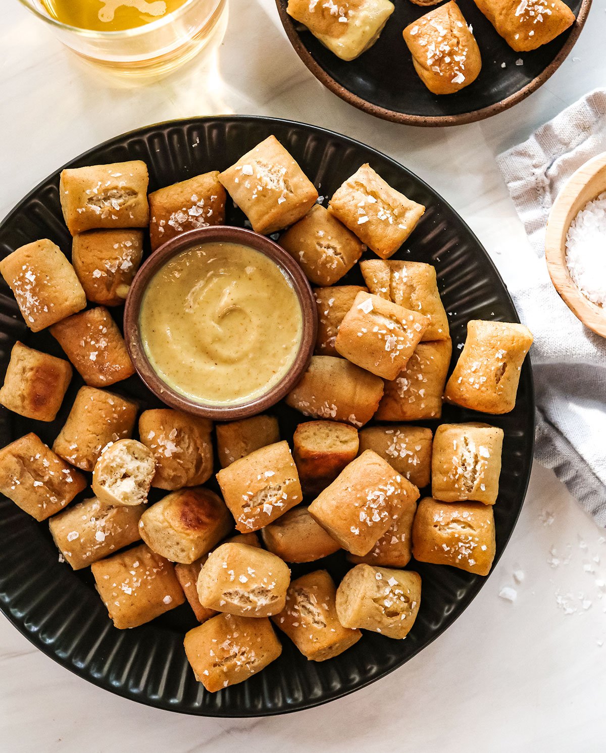 gluten-free pretzels on a black plate with honey mustard.