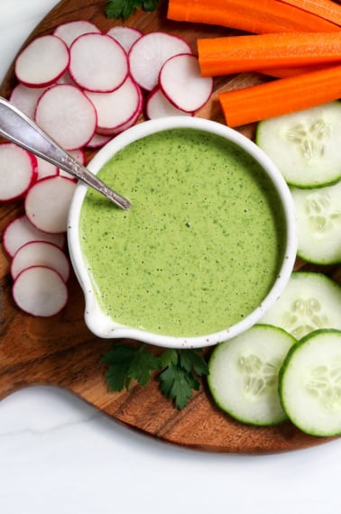 green goddess dressing served on a tray of veggies.