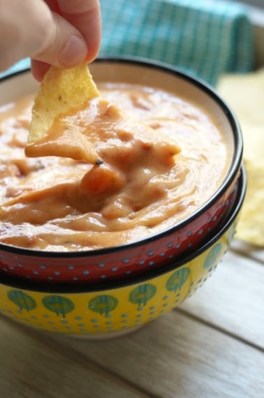 Dipping chip in sweet potato queso dip