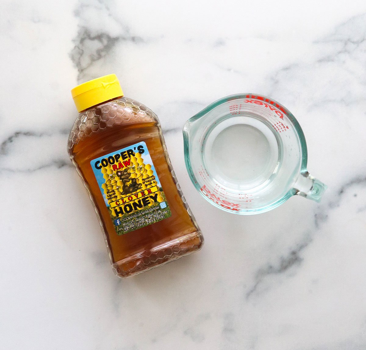 honey and water sitting on a marble surface.