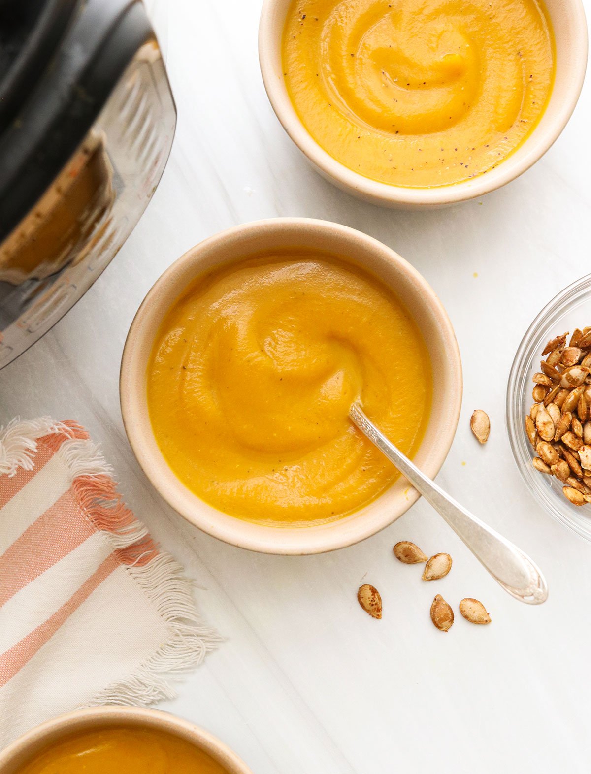 butternut squash soup served in bowls with spoon.