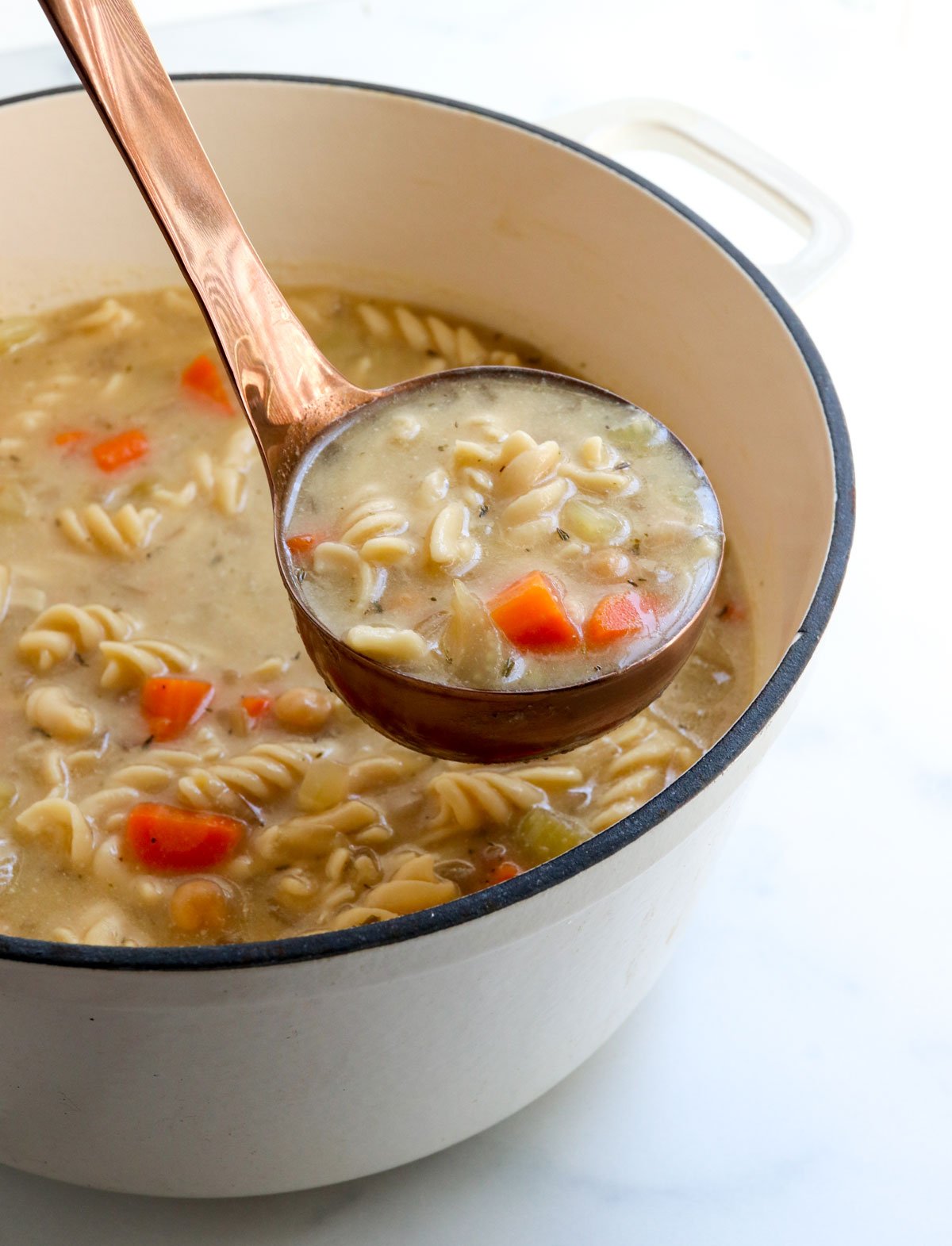 ladle lifting up chickpea noodle soup