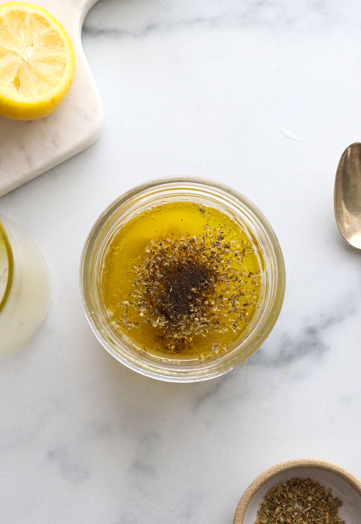 lemon salad dressing ingredients added to a small mason jar.