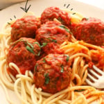 lentil meatballs on a plate of pasta with sauce labeled for Pinterest.