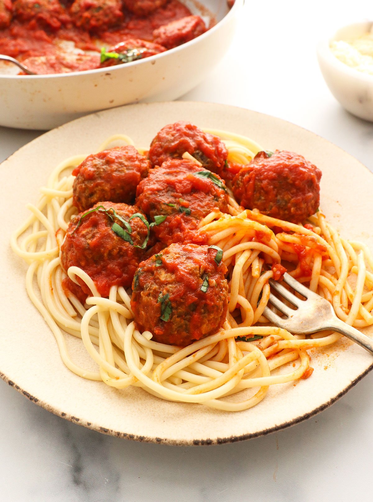 lentil meatballs in marinara sauce on a plate of spaghetti noodles.