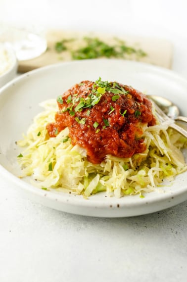 bowl of cabbage topped with spaghetti sauce