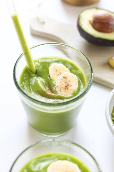 matcha smoothie in a glass with straw