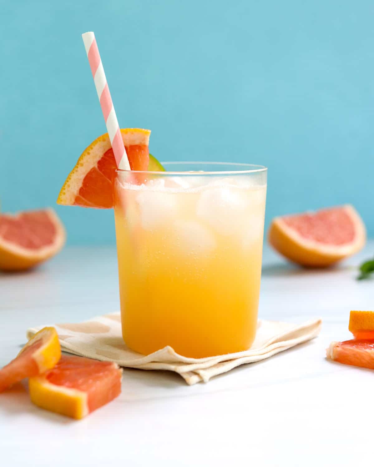 mocktail garnished with grapefruit with blue background.