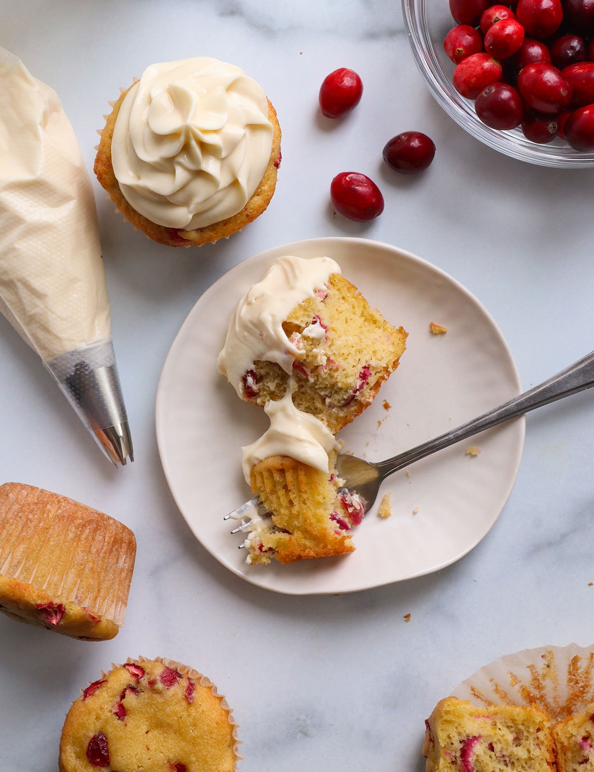 cupcake with cream cheese frosting eaten on a plate.