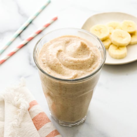 peanut butter banana smoothie in glass that looks like a milkshake.