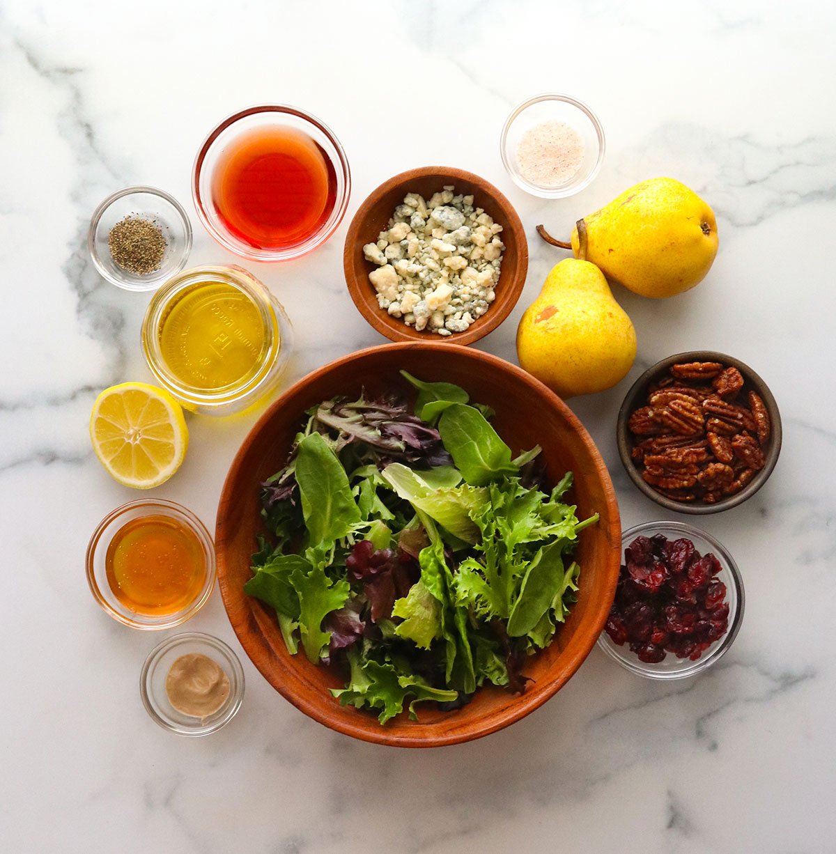 pear salad ingredients arranged on a marble surface.