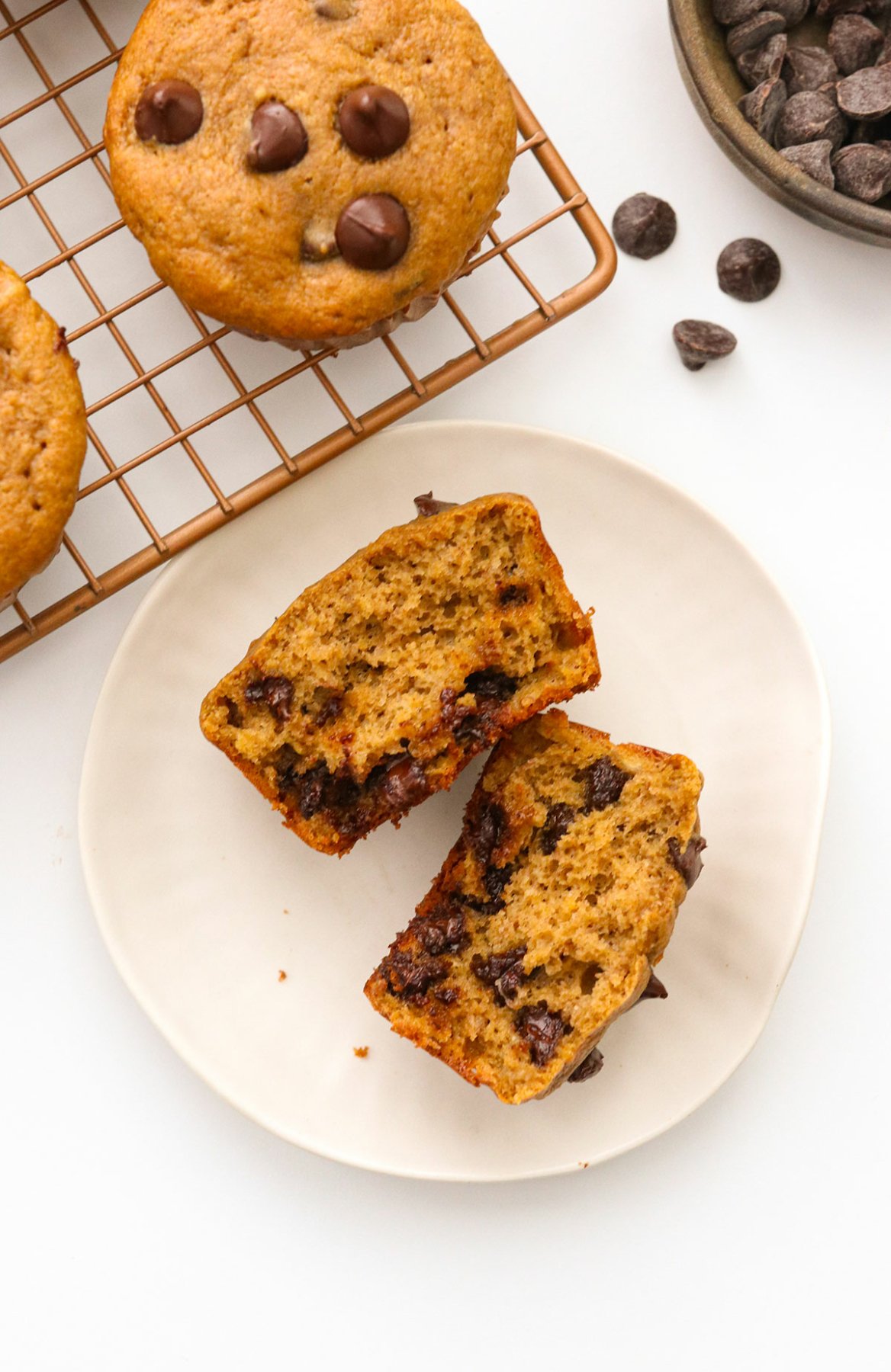 protein muffin split in half on a white plate.