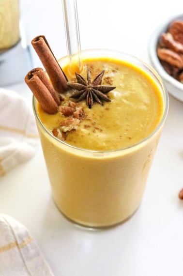 pumpkin smoothie in glass with cinnamon sticks