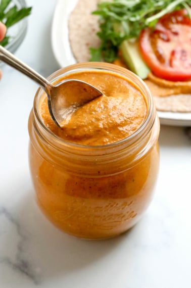 spoon in a jar of romesco sauce