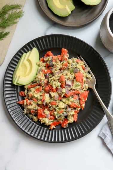 salmon and eggs on black plate with fork